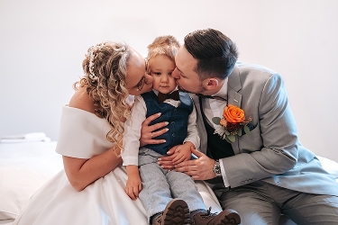 Rodiče dávají pusu synovi